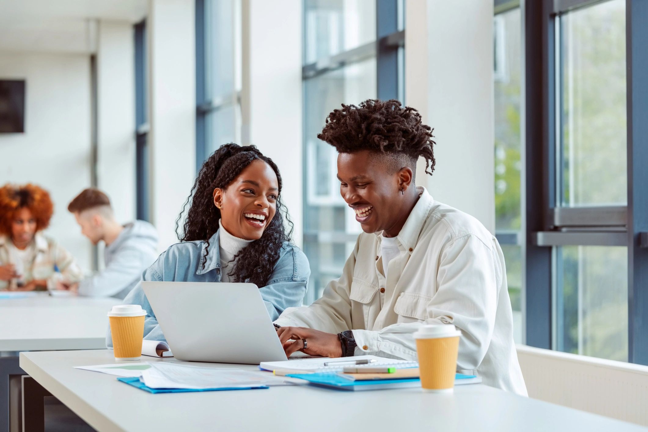 Two university students studying together over a laptop